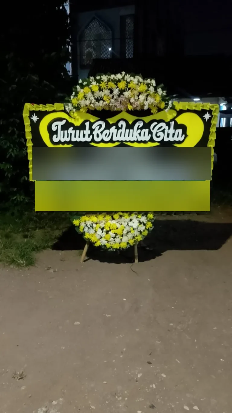 Papan bunga Turut Berduka Cita hitam-kuning selesai dirangkai pada malam hari