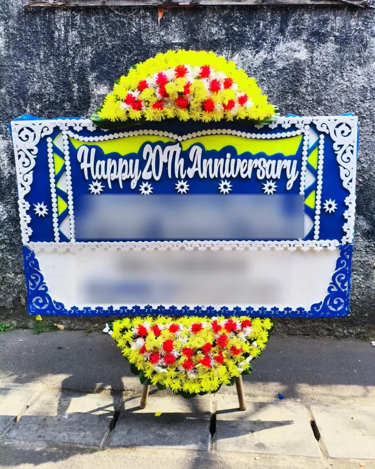 Papan bunga Happy 20th Anniversary biru-putih sebelum diantar ke Gedung SMESCO