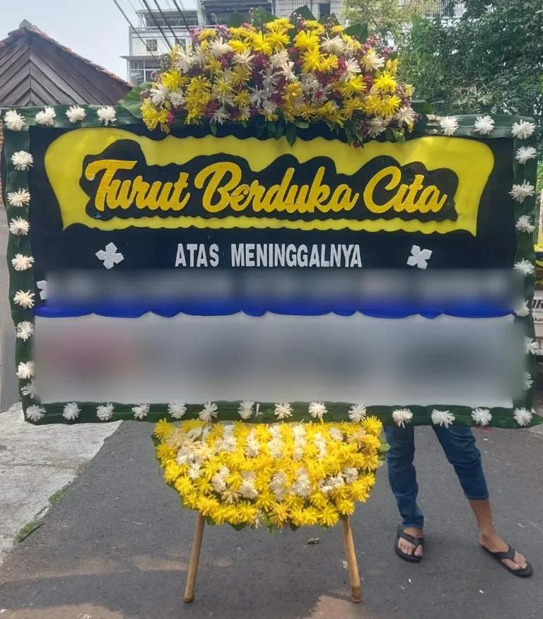 Papan bunga Turut Berduka Cita hitam-kuning dengan mahkota krisan sebelum diantar ke Mampang Prapatan