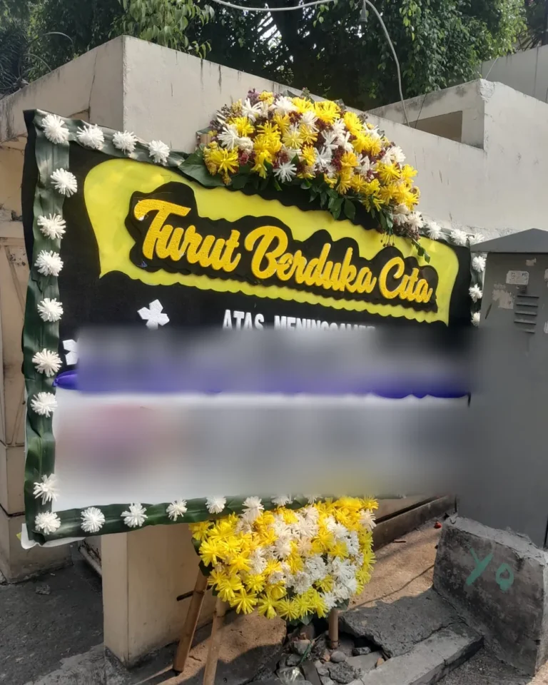 Papan bunga Turut Berduka Cita hitam-kuning terpasang di depan rumah duka di Mampang Prapatan